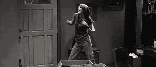a black and white photo of a woman dancing in a room .