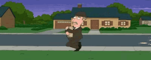 a man in a suit and hat is running down a street