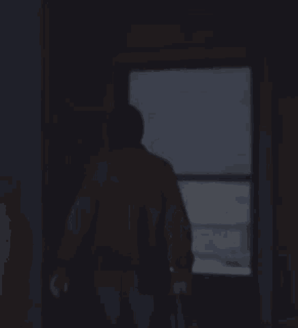 a window in a dark room with a reflection of a person in the window