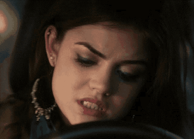 a close up of a woman 's face wearing earrings