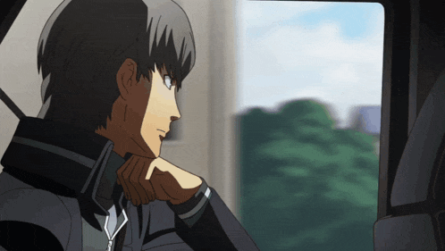 a man looking out a window with a hand on his chin