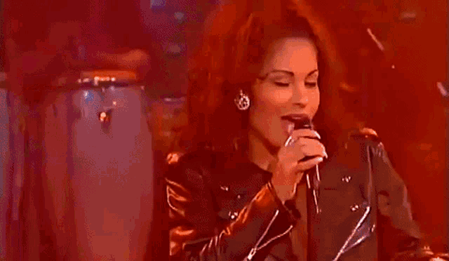 a woman is singing into a microphone with her tongue out .