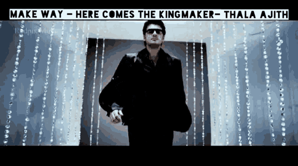 a man in a suit and sunglasses is standing in front of a wall of beads with the words make way here comes