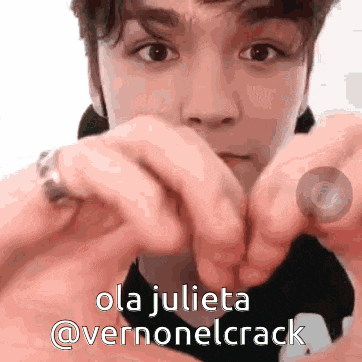 a young man making a heart shape with his hands and the words ola julieta @vernonelcrack