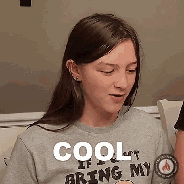 a girl wearing a gray shirt that says cool if you bring my