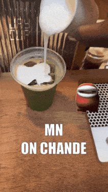 someone is pouring milk into a cup that says mn on chande on it