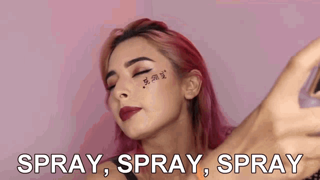 a woman with a tattoo on her face is spraying something on her face