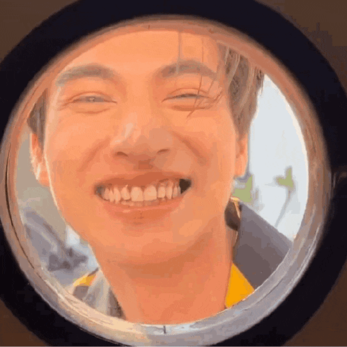 a close up of a man 's face smiling through a window .
