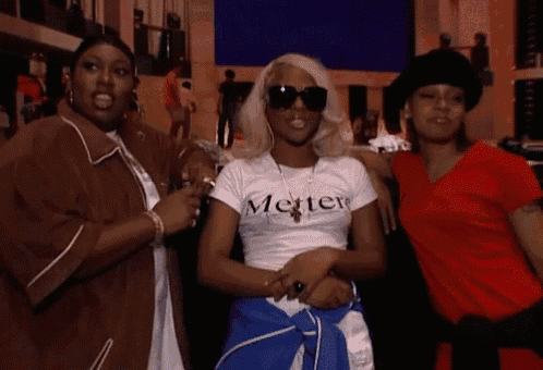 a woman wearing a white shirt that says metter stands between two other women