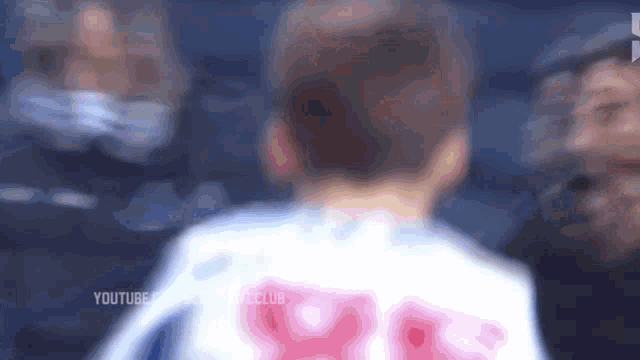 a blurry picture of a person wearing a white shirt with the number 99 on it .