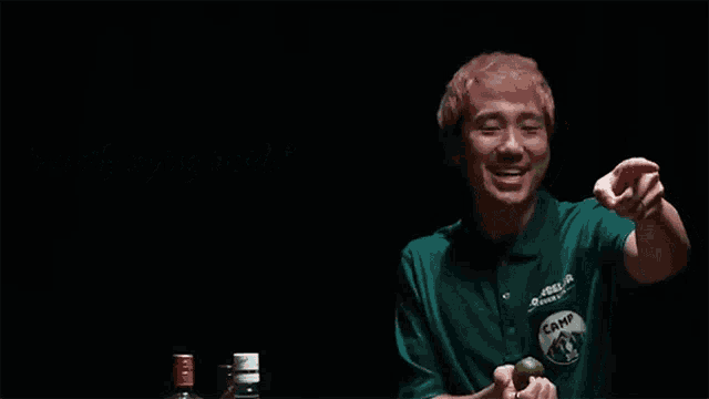 a man in a green shirt is pointing at the camera with the words secretly crying inside behind him