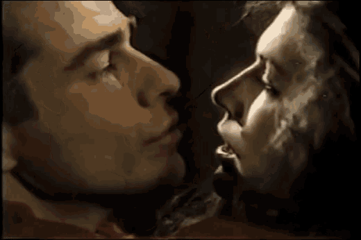 a close up of a man and woman kissing with smoke coming out of their mouths