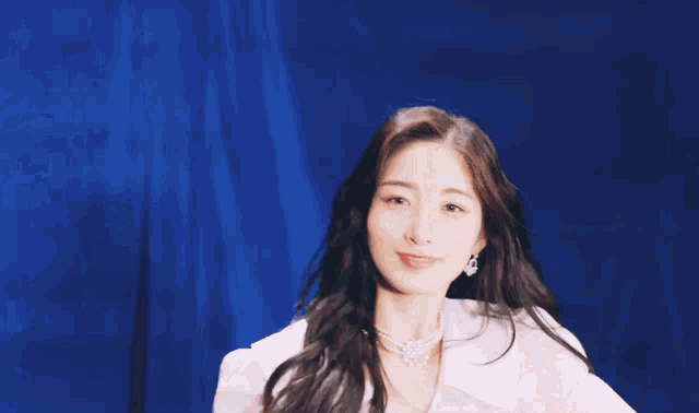 a woman with long dark hair is looking at the camera