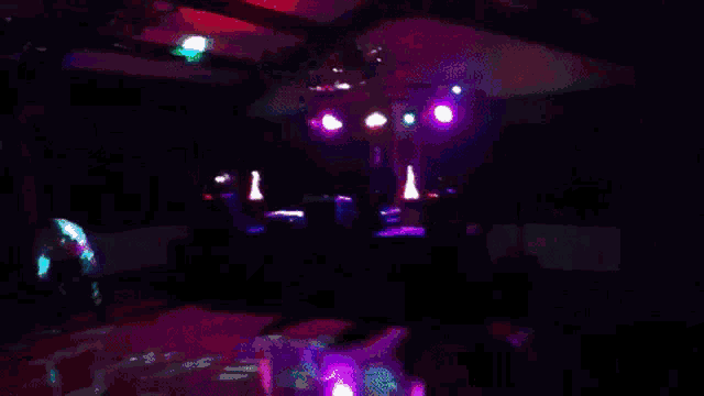 a blurred image of a dance floor with a blue light in the background