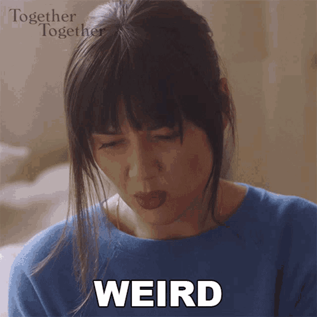 a woman in a blue sweater is making a face and the word weird is above her