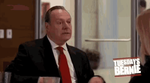 a man in a suit and tie is sitting in front of a woman .