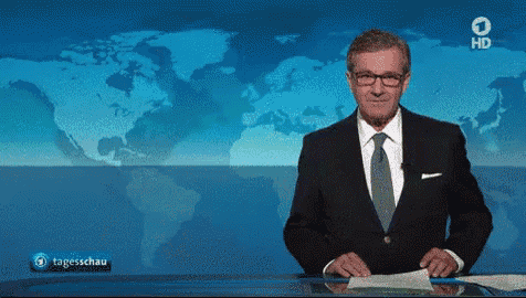 a man in a suit and tie is standing in front of a map of the world and says hd