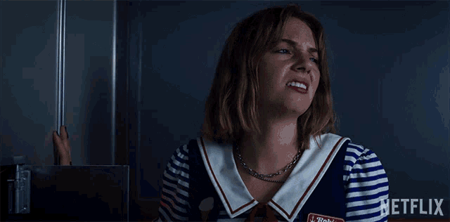 a woman in a striped shirt with a netflix logo on the bottom right