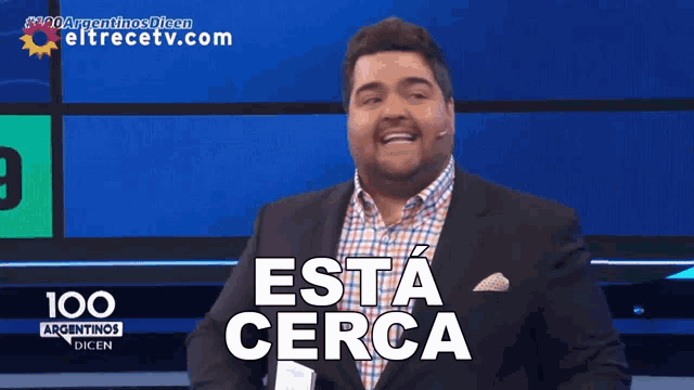 a man in a suit says " esta cerca " on a screen