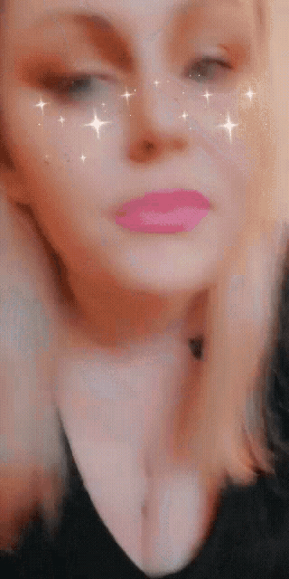 a close up of a woman 's face with pink lipstick and stars on her eyes .