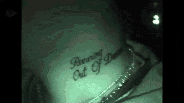 a person has a tattoo on their neck that says running out i do