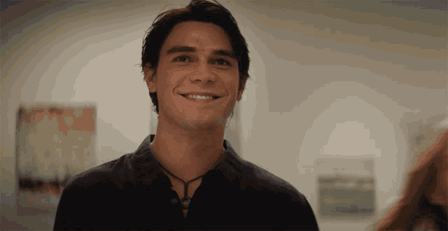 a man with a necklace around his neck smiles