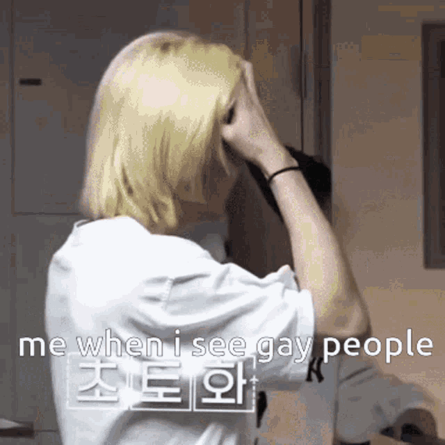 a person with blonde hair covering their face with their hand and the words " me when i see gay people " on the bottom