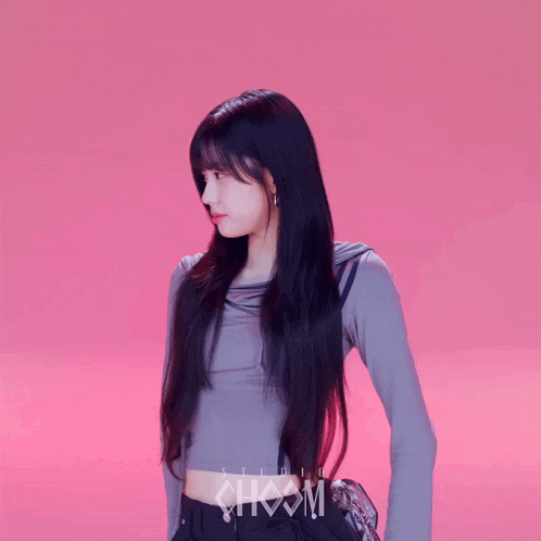 a girl with long black hair is wearing a crop top that says studio choom on the front