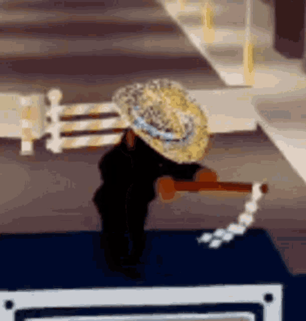a person wearing a straw hat is standing next to a barrier on the side of a road .