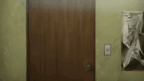 a wooden door is open to a room with a poster on the wall that says " the clash "