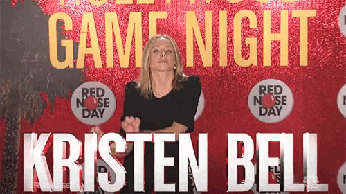 a woman stands in front of a sign that says game night and kristen bell