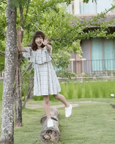 a woman in a dress is standing on a log