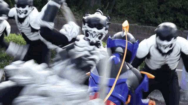a group of monsters are fighting each other and one of them is holding a sword