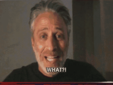 a man with a beard is smiling and saying " what ? "