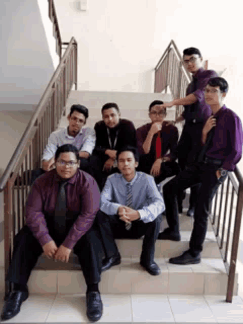 a group of men are posing for a picture on stairs