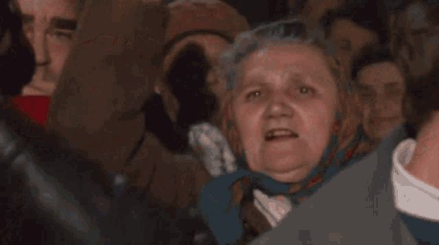 a woman is making a funny face in a crowd with the word selfies on the bottom