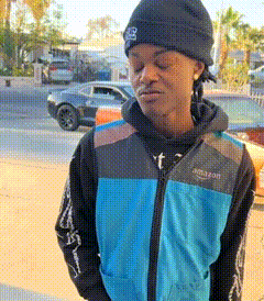 a man wearing a black beanie and a blue vest that says amazon on it