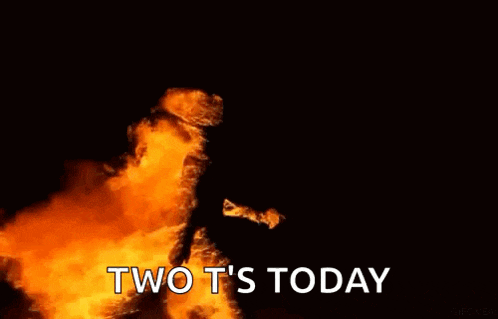 a person is standing in front of a large fire with the words `` two t 's today '' written below it .