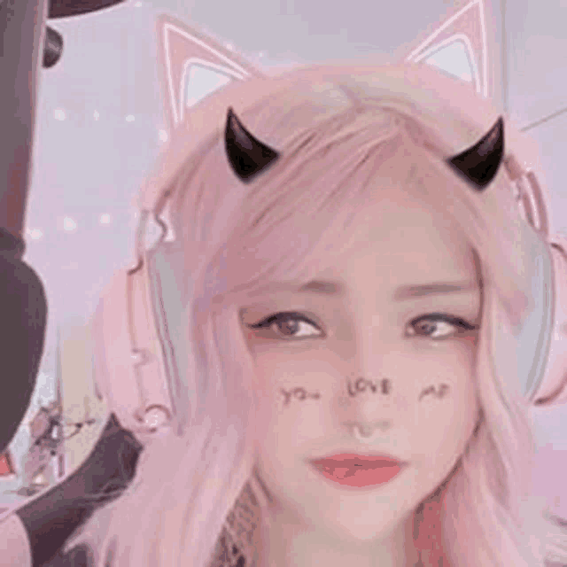 a girl with pink hair and horns is wearing headphones and a cat ear mask .