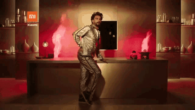 a man is dancing in a kitchen with a xiaomi logo in the background