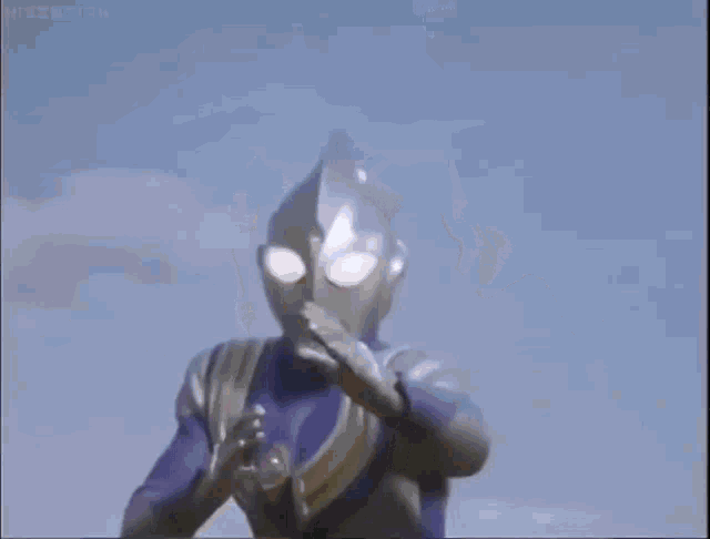 a blurred image of a superhero in a purple suit standing in a field .