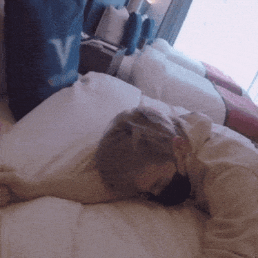 a person is laying on a bed with a bag that says v on it
