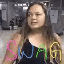 a woman wearing a black tank top with the word swag written on her arm .