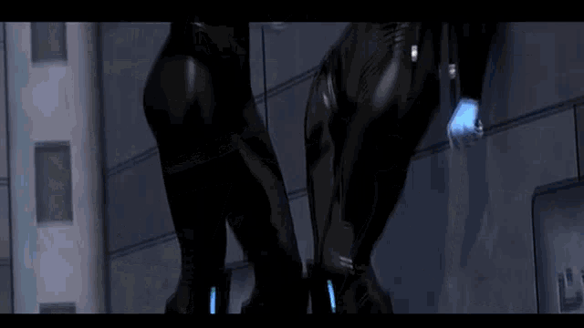 two women in black suits are standing next to each other in a room .