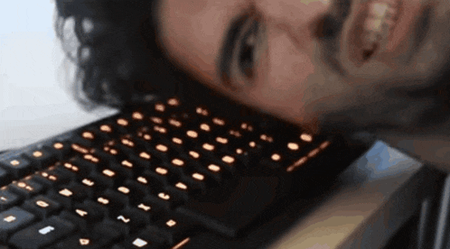 a man laying on top of a keyboard that has the letters a and b on it