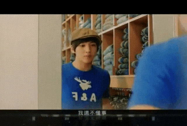 a young man wearing a blue t-shirt with a moose on it