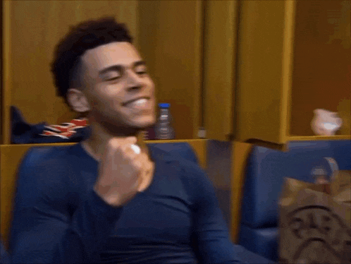 a man in a blue shirt is sitting in a locker room