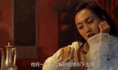 a woman in a white shirt is sitting in front of a vase with chinese writing on it