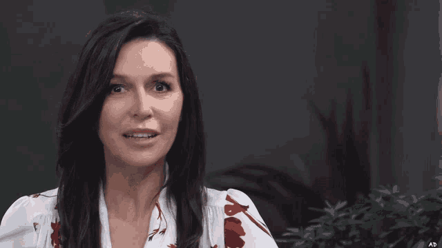 a woman in a white shirt with red flowers on it