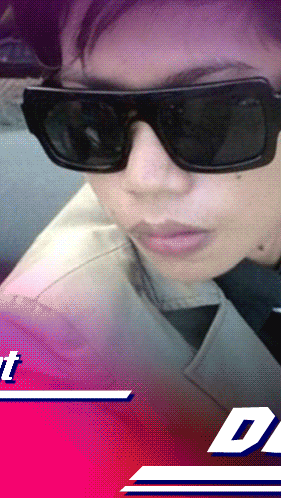 a close up of a person wearing sunglasses with a pink background